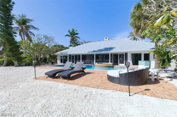 a view of a house with backyard and sitting area
