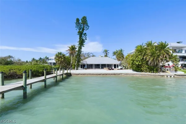 a view of a house with a yard and palm trees