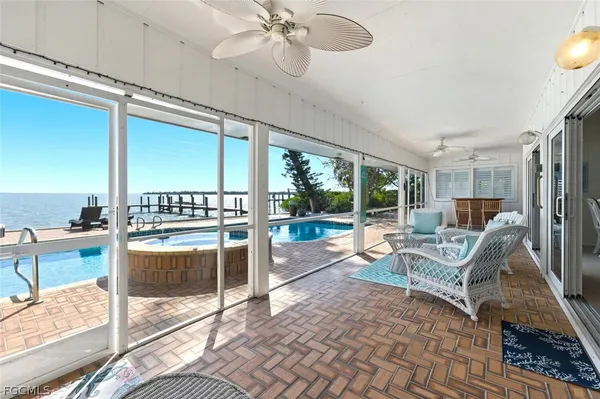 a living room with patio furniture and a floor to ceiling window