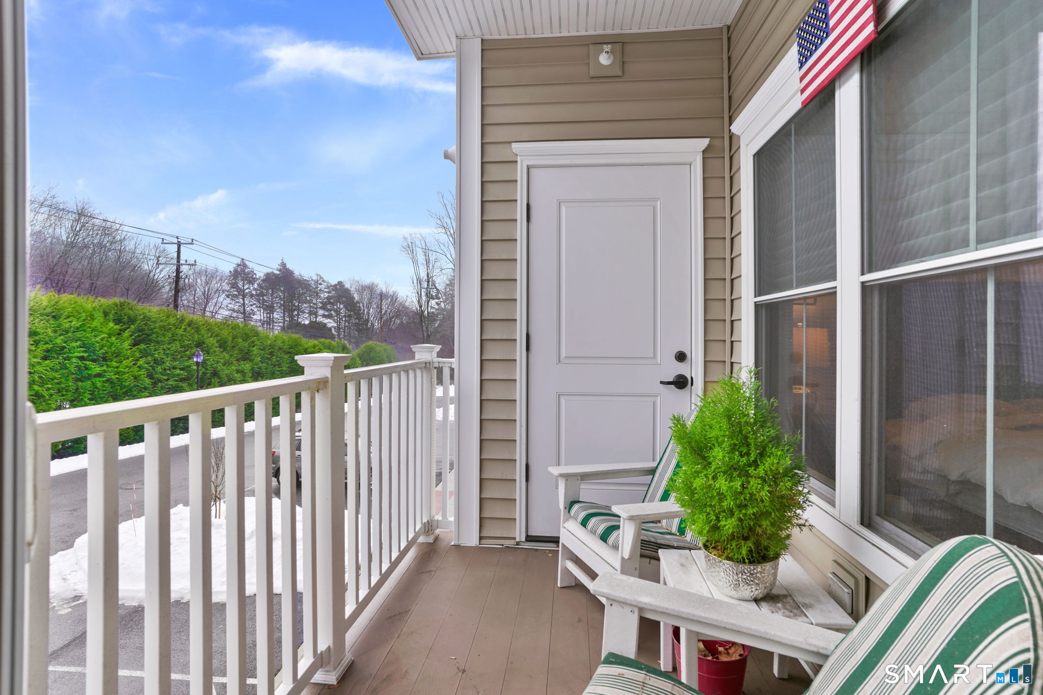 233 Danbury Road, Unit A209 Ridgefield, CT 06877 - Photo 18 of 25 a balcony with potted plants and wooden fence