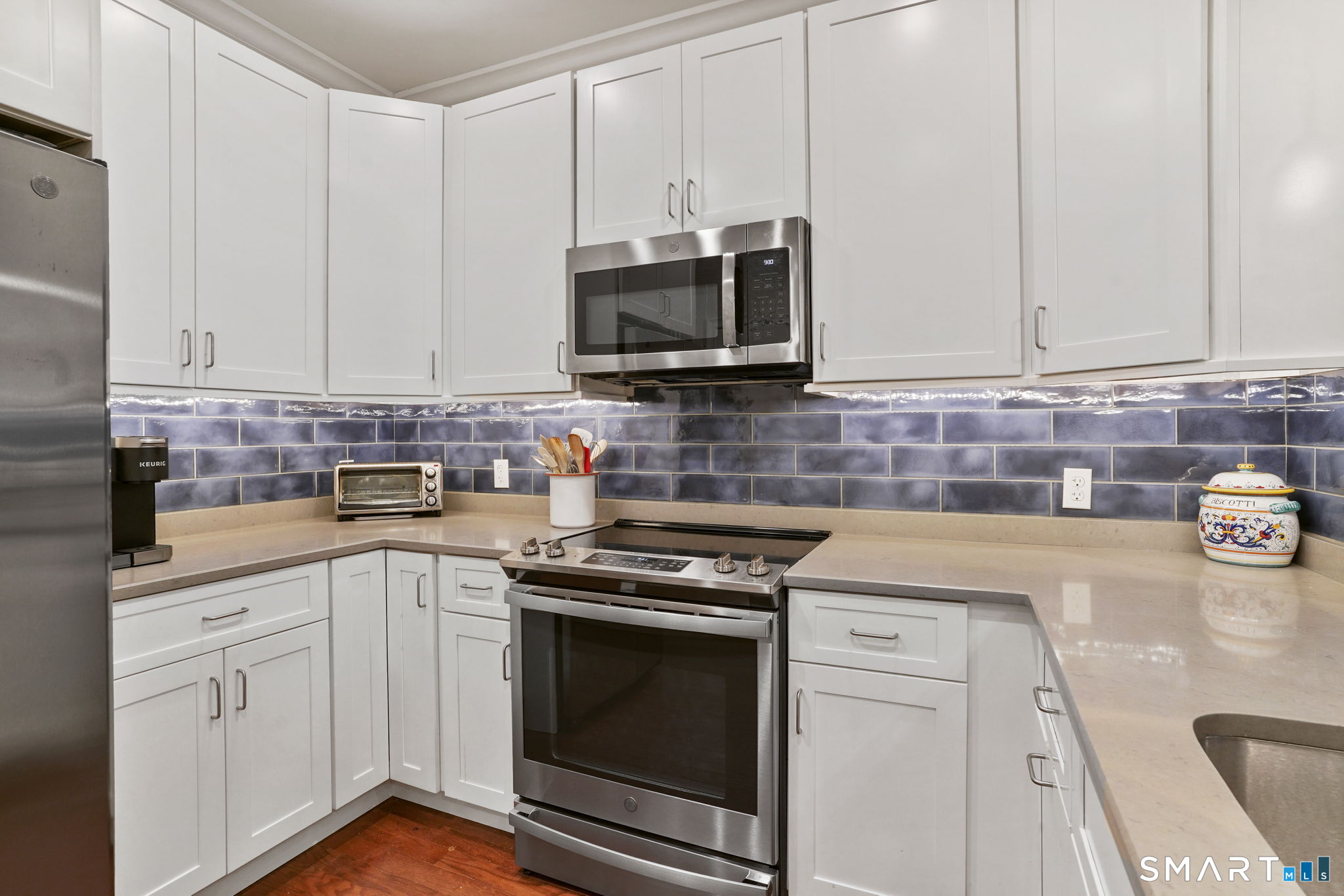 233 Danbury Road, Unit A209 Ridgefield, CT 06877 - Photo 4 of 25 a kitchen with stainless steel appliances granite countertop a sink a stove and a microwave