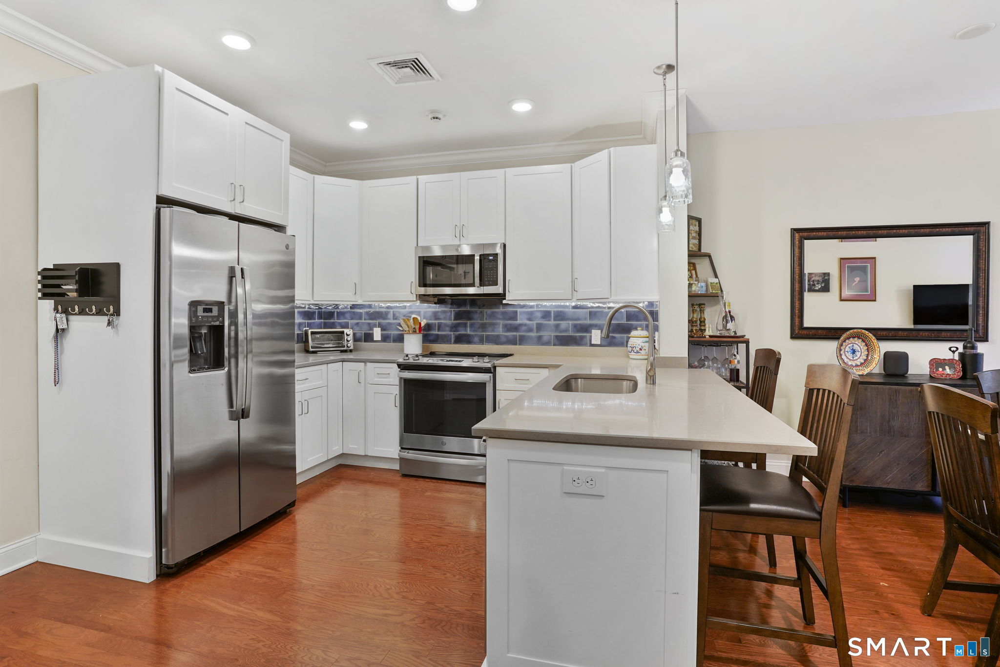 233 Danbury Road, Unit A209 Ridgefield, CT 06877 - Photo 5 of 25 a kitchen with stainless steel appliances a stove a sink a refrigerator a center island and chairs