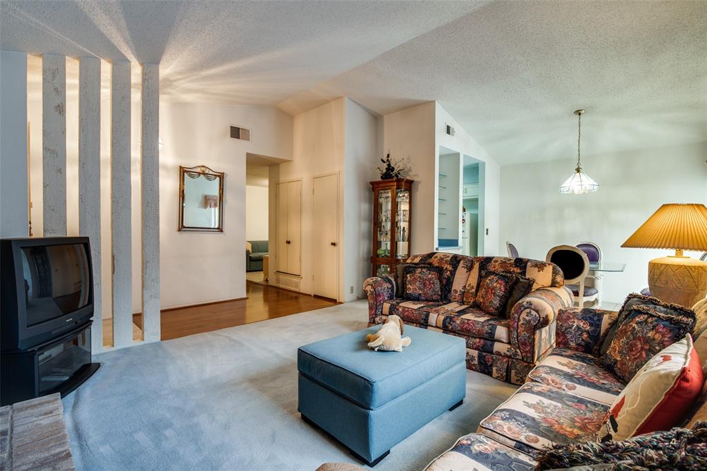1916 Cobblestone Lane Garland, TX 75042 - Photo 13 of 33 Carpeted living area with vaulted ceiling and a textured ceiling