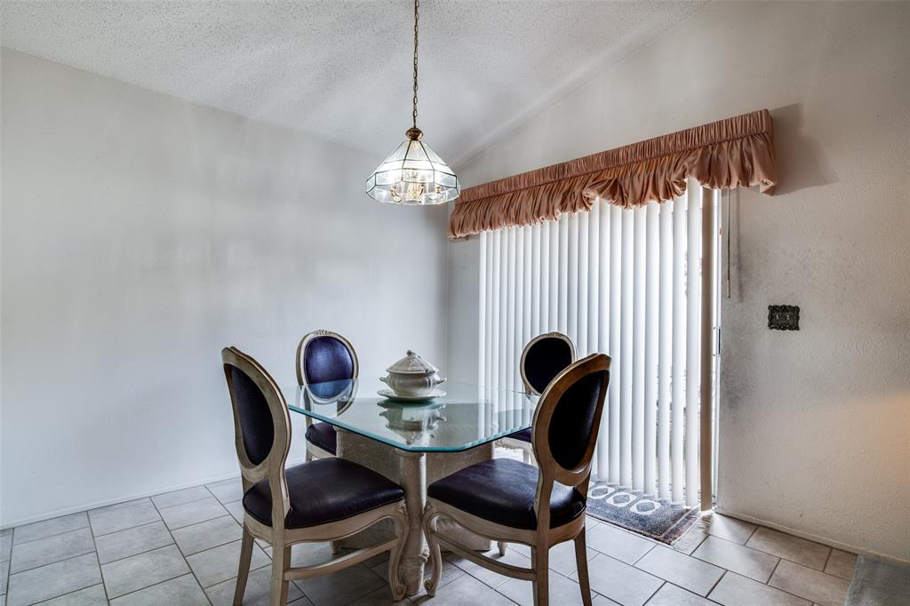 1916 Cobblestone Lane Garland, TX 75042 - Photo 14 of 33 Dining area with a chandelier, a textured ceiling, lofted ceiling, and light tile patterned floors