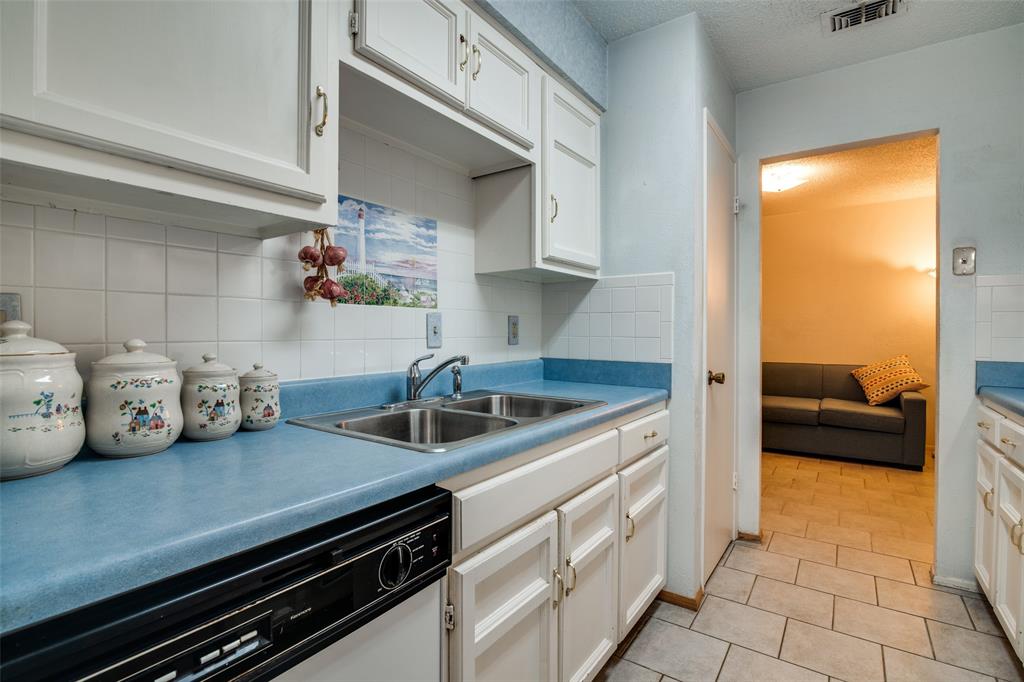 1916 Cobblestone Lane Garland, TX 75042 - Photo 18 of 33 Kitchen with dishwasher, a sink, decorative backsplash, light tile patterned floors, and a textured ceiling