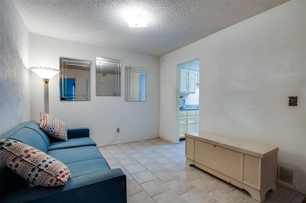 1916 Cobblestone Lane Garland, TX 75042 - Photo 21 of 33 Living area featuring electric panel, a textured ceiling, and light tile patterned flooring