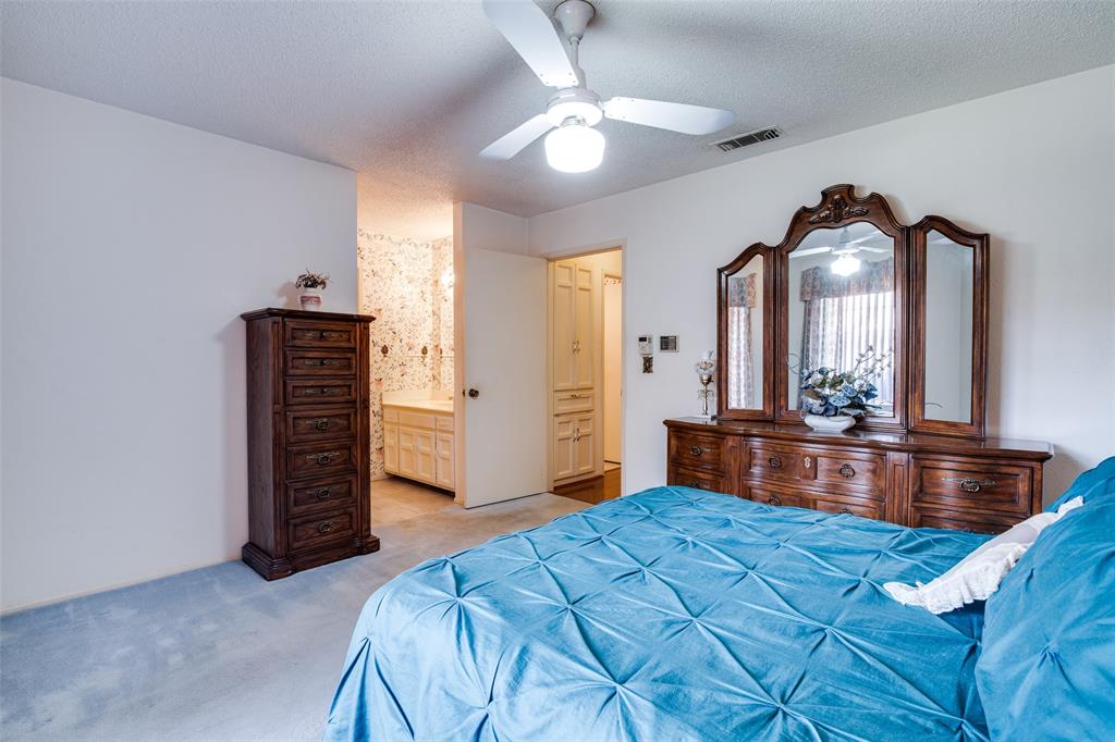 1916 Cobblestone Lane Garland, TX 75042 - Photo 24 of 33 Bedroom with light carpet, a textured ceiling, a ceiling fan, and ensuite bath