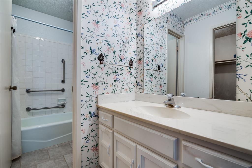 1916 Cobblestone Lane Garland, TX 75042 - Photo 26 of 33 Full bath with vanity, a textured ceiling, shower / bath combination with curtain, and wallpapered walls