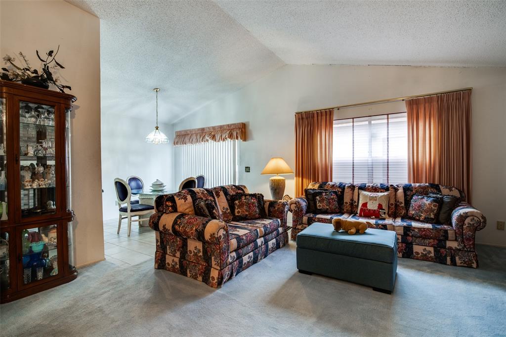 1916 Cobblestone Lane Garland, TX 75042 - Photo 10 of 33 Carpeted living area with lofted ceiling and a textured ceiling