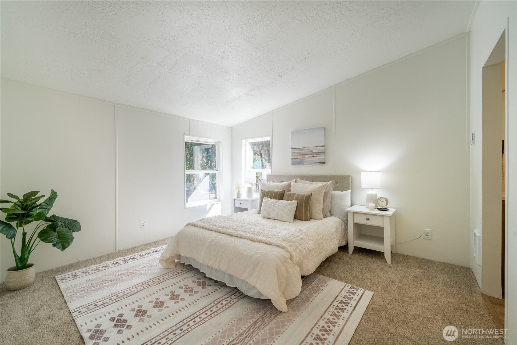 3408 Old Highway 99 North Road Burlington, WA 98233 - Photo 13 of 38 a bedroom with a large bed and a potted plant