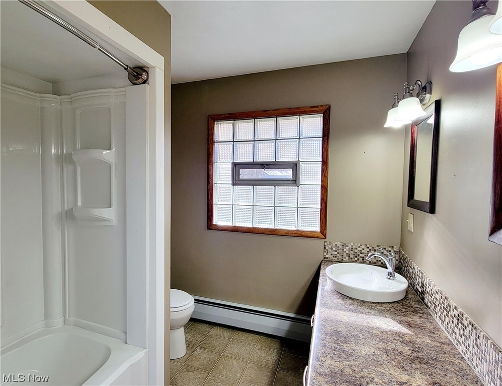 405 Bryan Road Milan, OH 44846 - Photo 17 of 35 Full bathroom with vanity, tile flooring, a baseboard heating unit, toilet, and shower combination