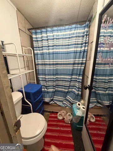 a bathroom with a toilet and a shower