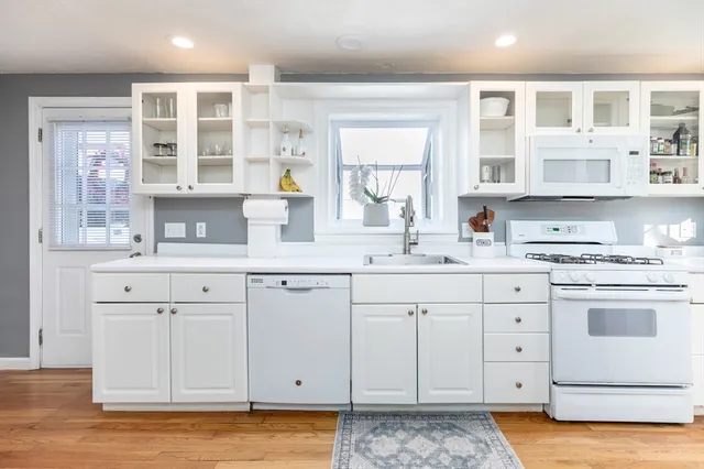 a kitchen with granite countertop white cabinets and white appliances