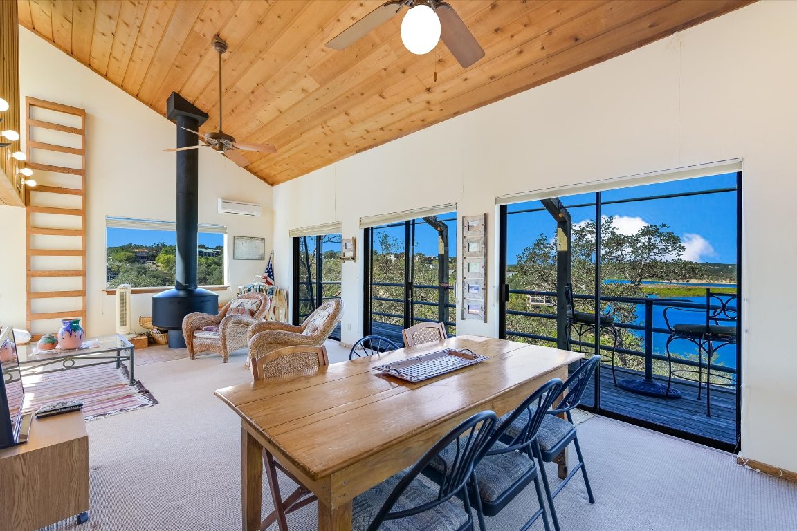 501 Coventry Road Spicewood, TX 78669 - Photo 12 of 24 a view of a dining room with furniture large windows and wooden floor