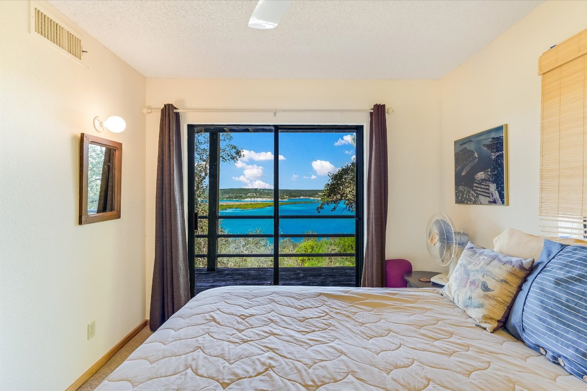 501 Coventry Road Spicewood, TX 78669 - Photo 14 of 24 a bedroom with a large bed and a window