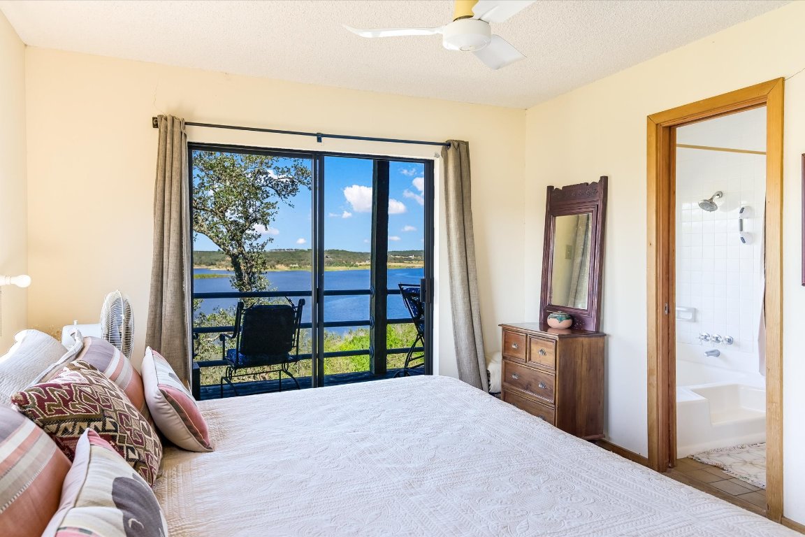 501 Coventry Road Spicewood, TX 78669 - Photo 15 of 24 a bedroom with furniture and large window