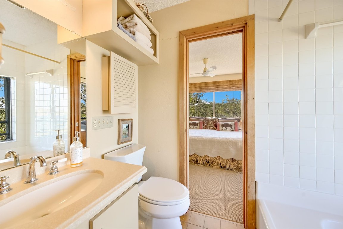 501 Coventry Road Spicewood, TX 78669 - Photo 17 of 24 a bathroom with a granite countertop sink toilet and shower