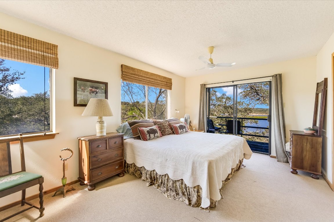 501 Coventry Road Spicewood, TX 78669 - Photo 18 of 24 a bedroom with a bed flat screen tv and window