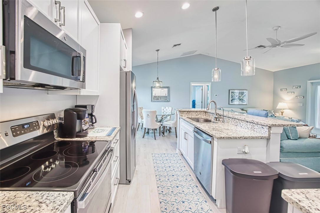 431 Lazy Way Fort Myers Beach, FL 33931 - Photo 17 of 40 a kitchen with a stove and a sink