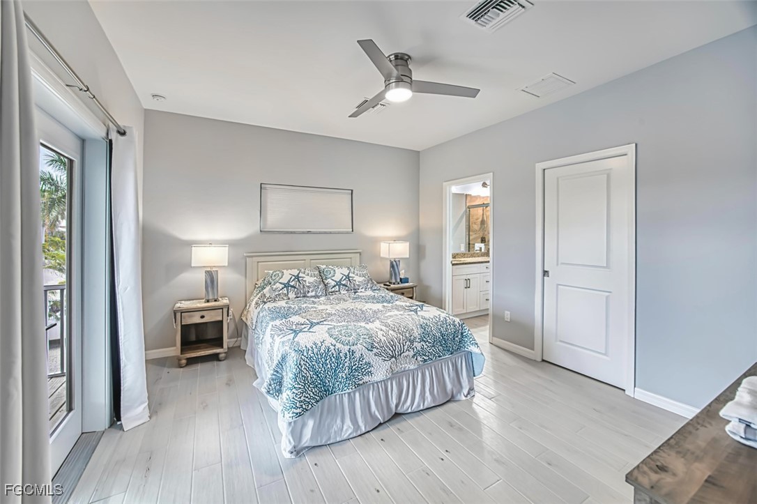 431 Lazy Way Fort Myers Beach, FL 33931 - Photo 23 of 40 a bedroom with a large bed and a chandelier