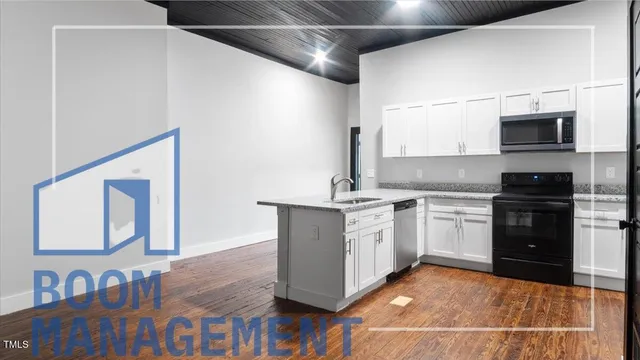 a kitchen with stainless steel appliances granite countertop a sink stove and cabinets