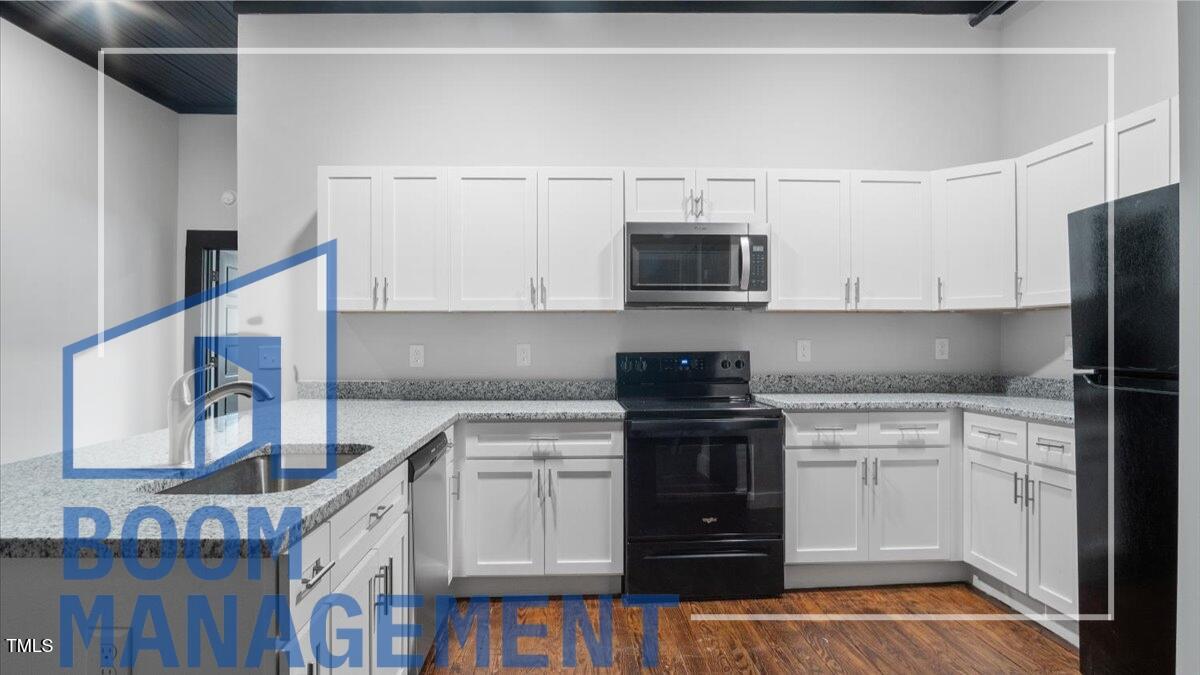 202 South Main Street, Unit 1BR 1 Bath, NC 27808 - Photo 13 of 31 a kitchen with stainless steel appliances granite countertop a stove a sink and a microwave