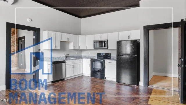 a kitchen with a refrigerator and a stove top oven