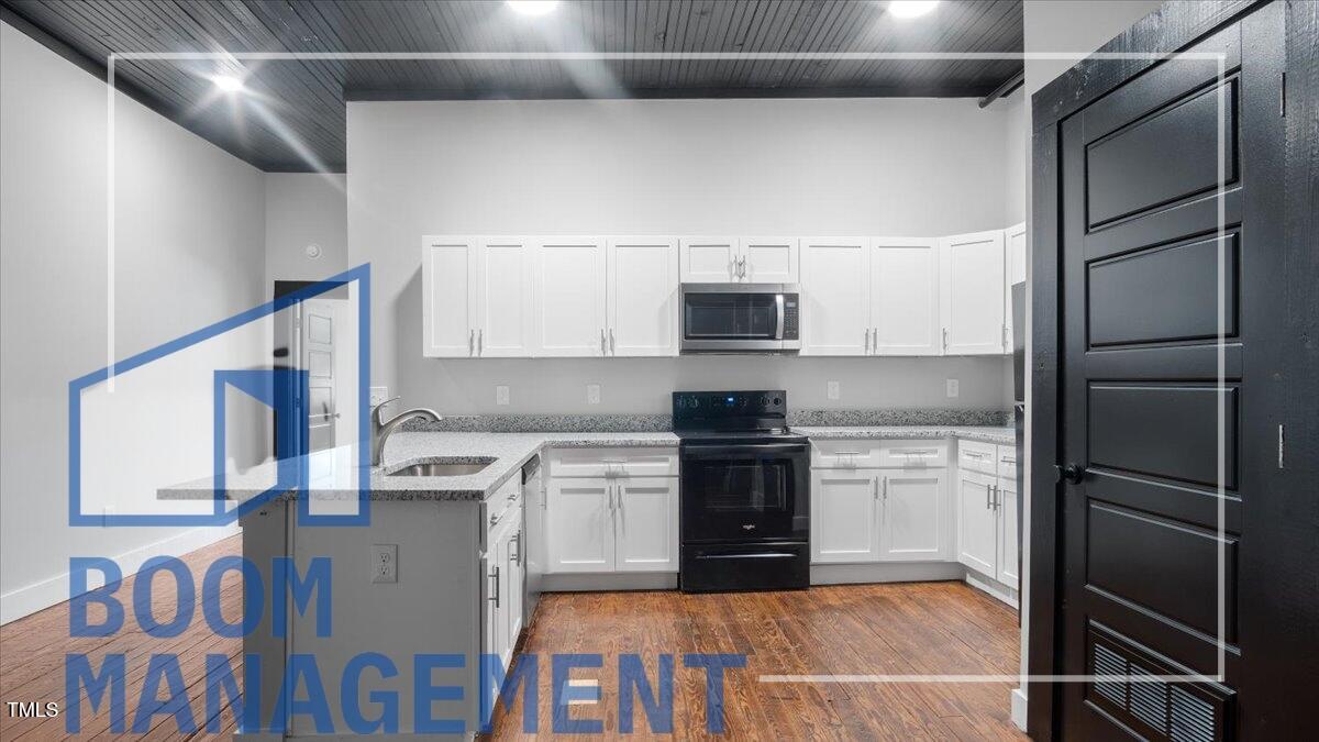 202 South Main Street, Unit 1BR 1 Bath, NC 27808 - Photo 10 of 31 a kitchen with stainless steel appliances granite countertop a refrigerator and a stove top oven