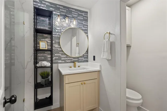 a bathroom with a toilet a sink and mirror