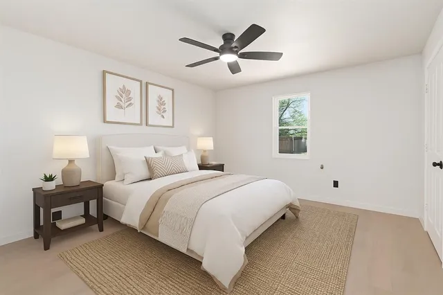 a spacious bedroom with a bed and a ceiling fan