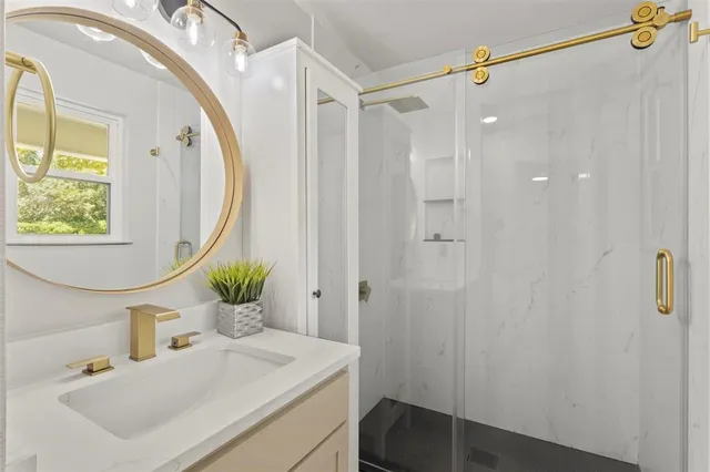a bathroom with a sink vanity granite tub and shower