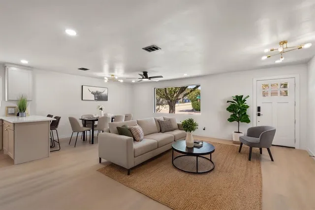 a living room with furniture a rug and a chandelier