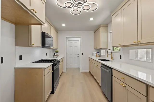 a kitchen with stainless steel appliances granite countertop a sink and a stove