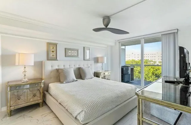 a bedroom with a large bed and a flat tv screen on dresser