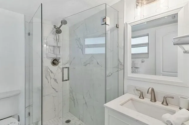 a bathroom with a sink shower and a mirror