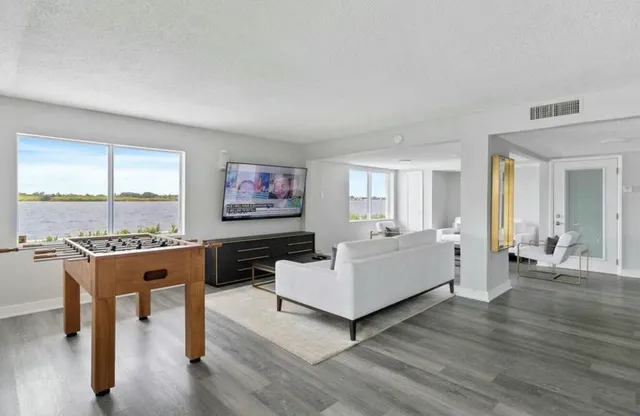 a living room with furniture flat screen tv and wooden floor