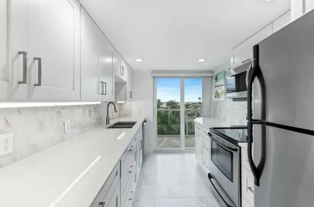 a kitchen with stainless steel appliances a refrigerator sink and stove