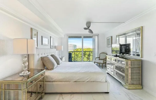 a bedroom with a large bed and a flat tv screen on dresser