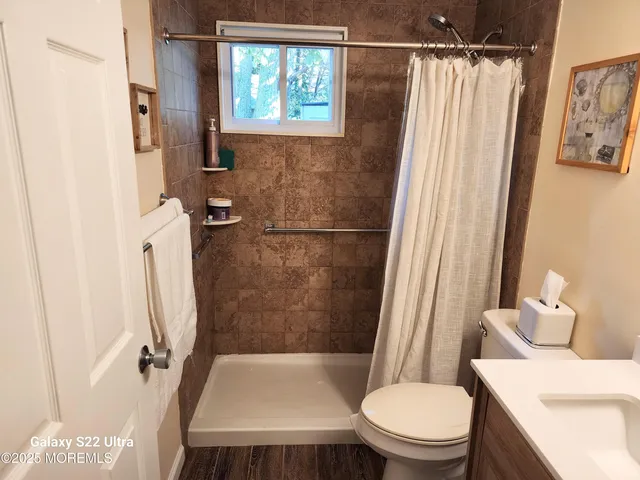 a white toilet sitting next to a bathroom sink and a shower