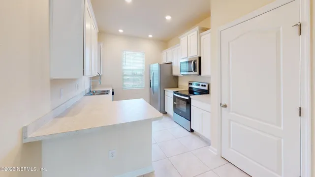a large kitchen with stainless steel appliances a refrigerator and a stove