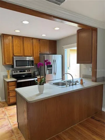 a kitchen with kitchen island granite countertop a sink counter top space appliances and cabinets