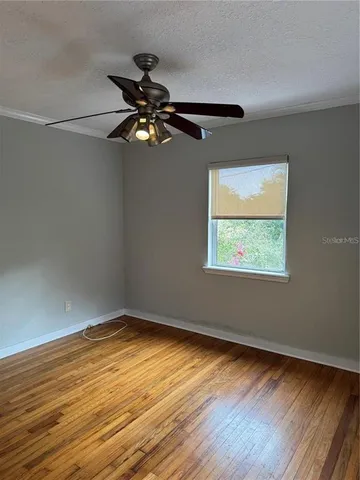 a view of room with wooden floor fan and windows