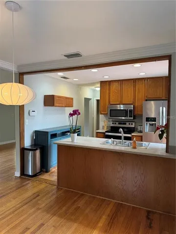 a kitchen with stainless steel appliances a stove a sink and a refrigerator