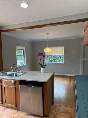 a room with kitchen island a sink a stove and a window