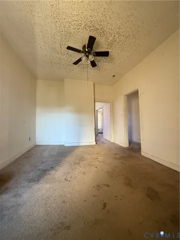 a view of a hallway with wooden floor and a bathroom