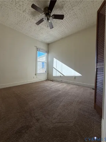 a view of empty room with ceiling fan
