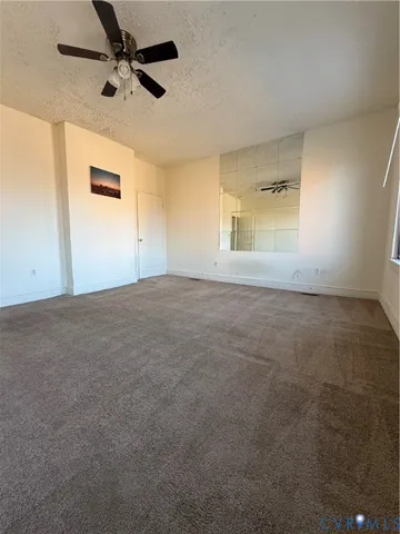 a view of an empty room with a ceiling fan