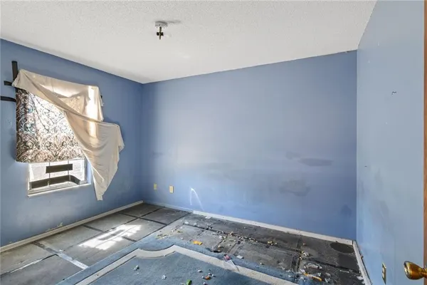 an empty room with closet and a window