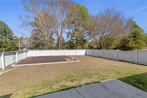 a view of a house with backyard and trees