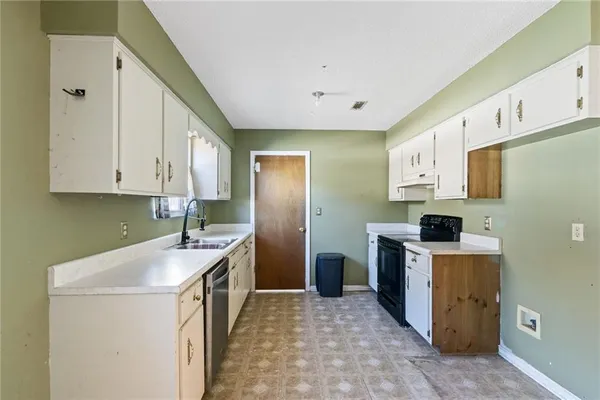 a kitchen with granite countertop a sink a stove and refrigerator